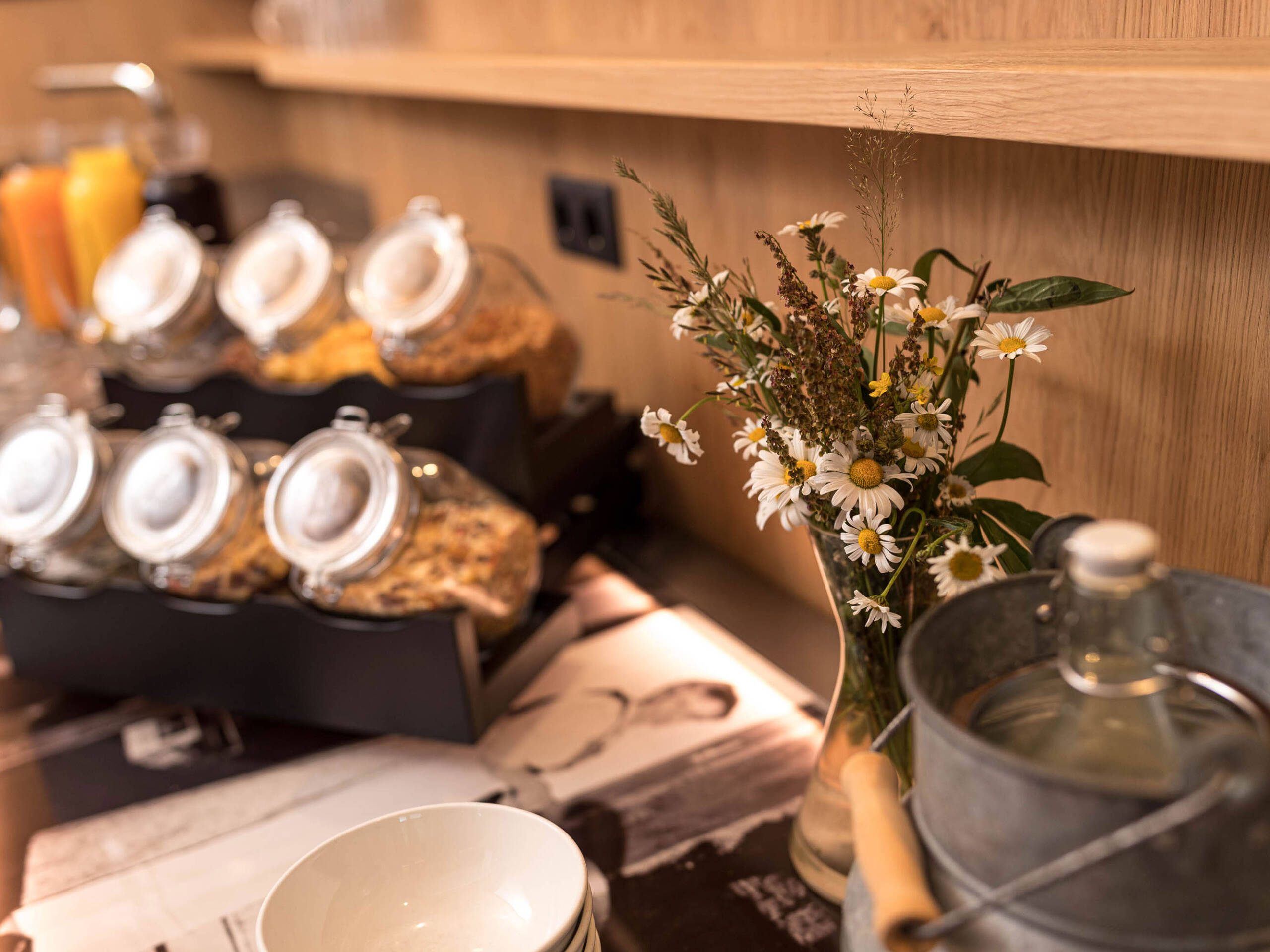 Verschiedene Müslisorten und ein Strauß Wiesenblumen am Frühstücksbuffet - Hotel Patriarch