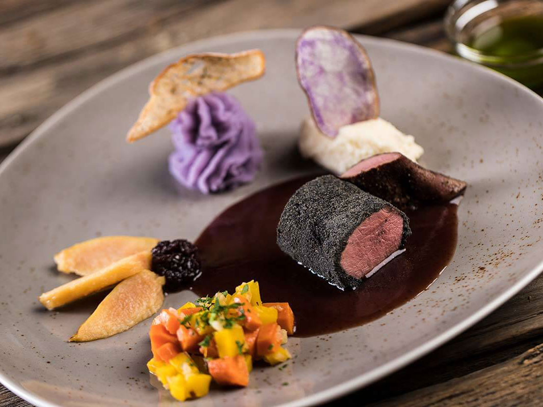 Schön angerichtetes Fleischgericht in einer Sauce und verschiedene Beilagen - Hotel Patriarch