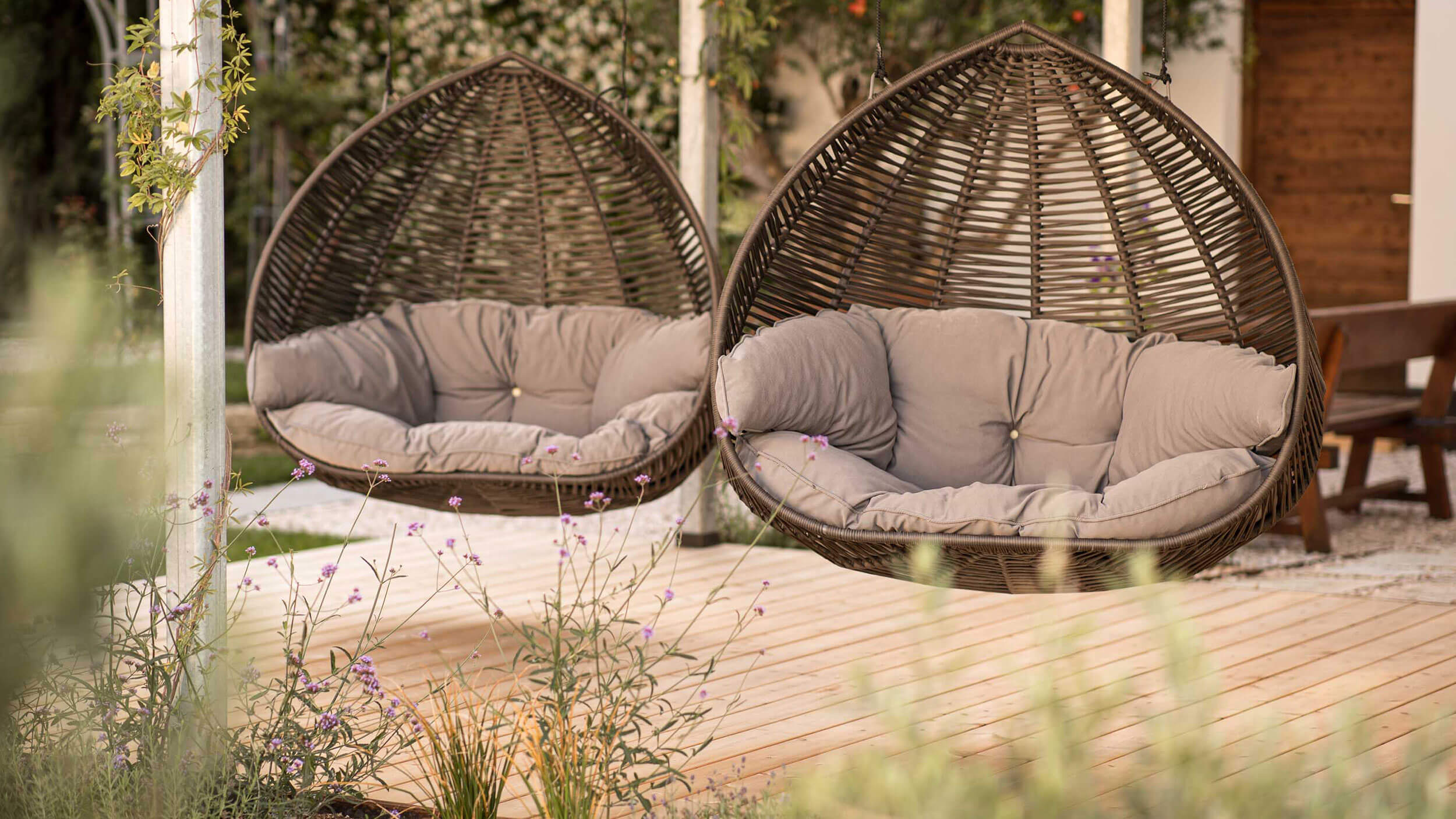 Zwei Hängekörbe mit hellbraunen Kissen - Hotel Patriarch