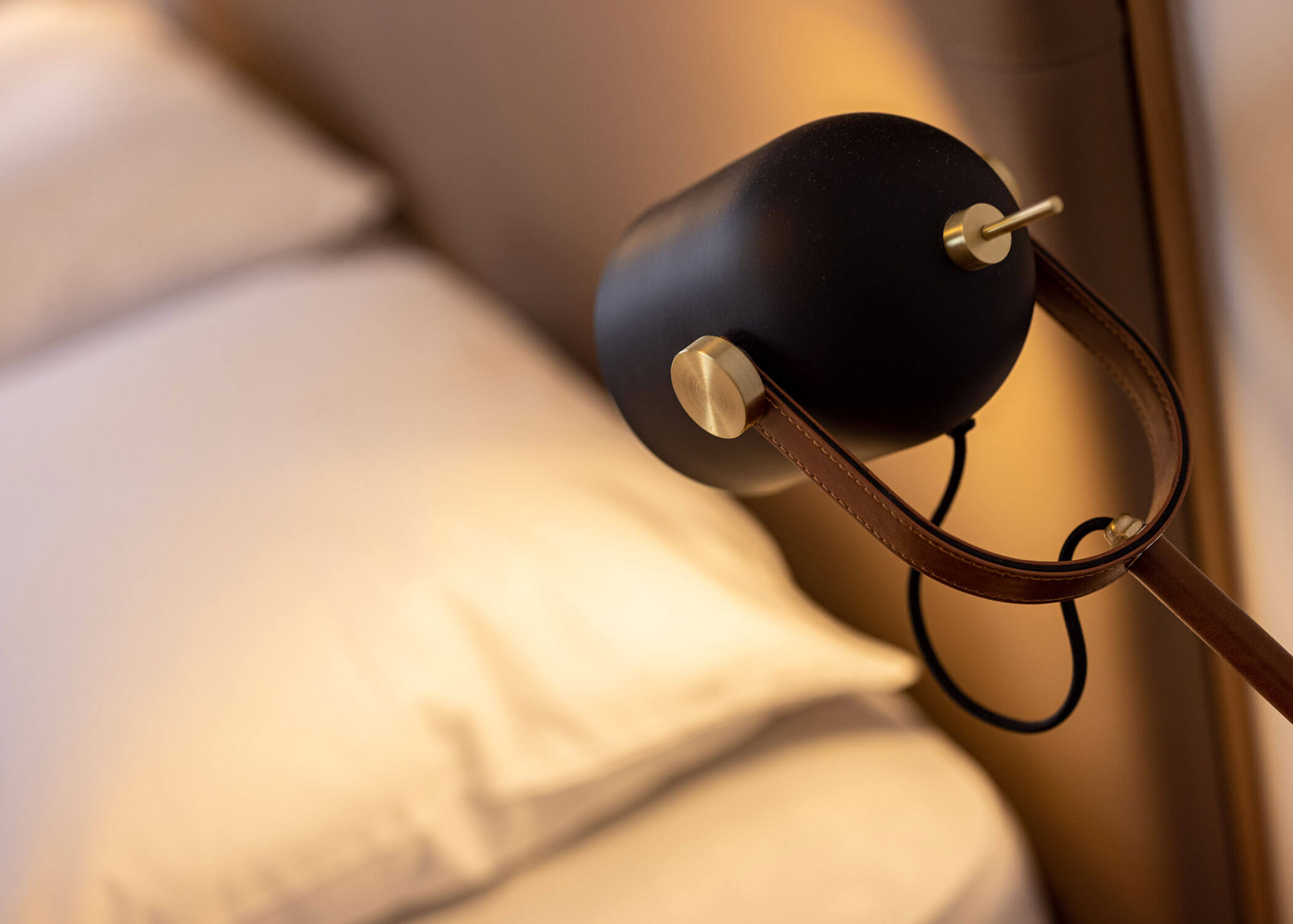 Eingeschaltete Nachttischlampe neben dem Bett - Hotel Patriarch