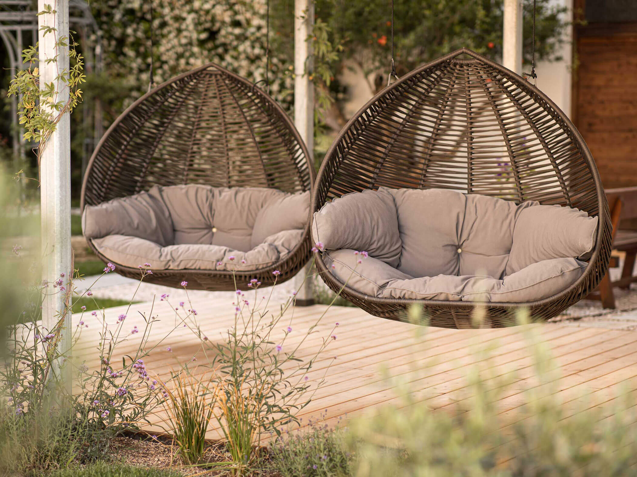 Two hanging chairs with light brown cushions - Hotel Patriarch