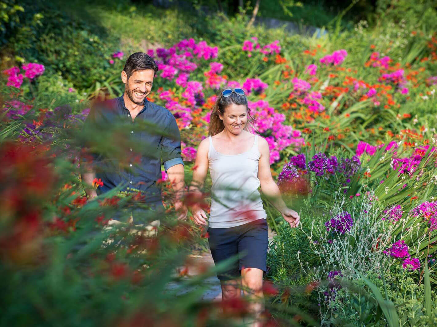 Ein Paar spaziert durch einen Blumengarten - Hotel Patriarch