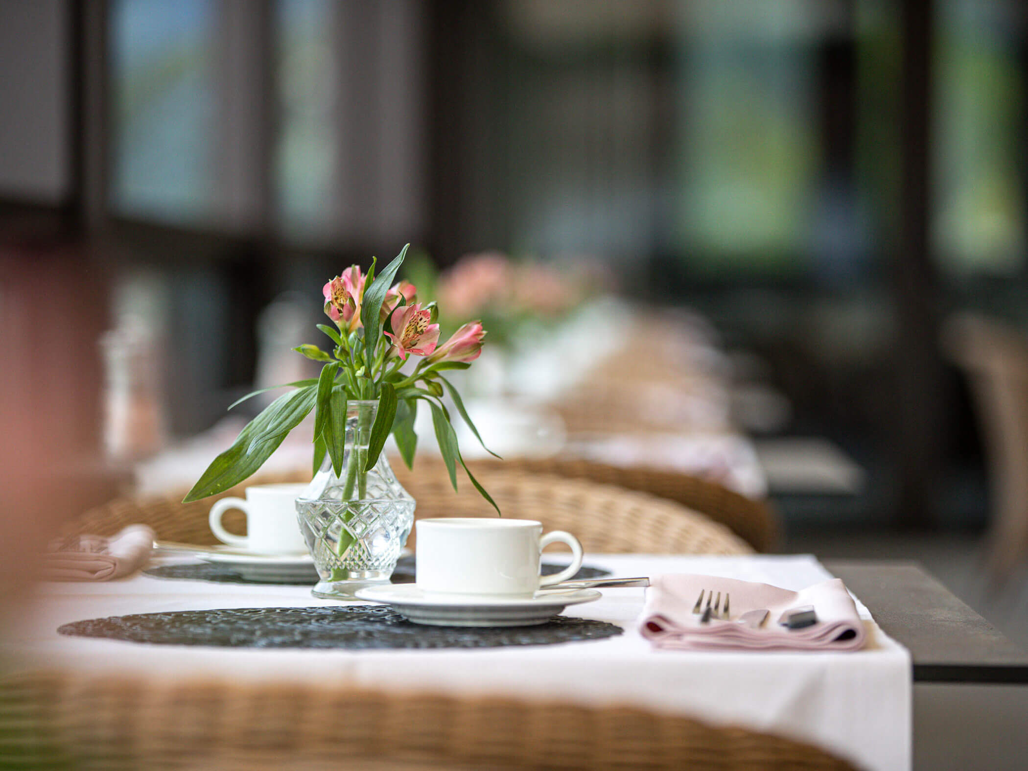 Gedeckter Tisch mit zwei Tassen und einer Blume in der Tischmitte - Hotel Patriarch