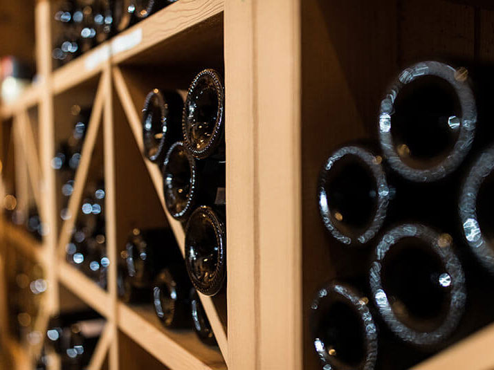 Mehrere Weinflaschen im Weinregal im Weinkeller - Hotel Patriarch