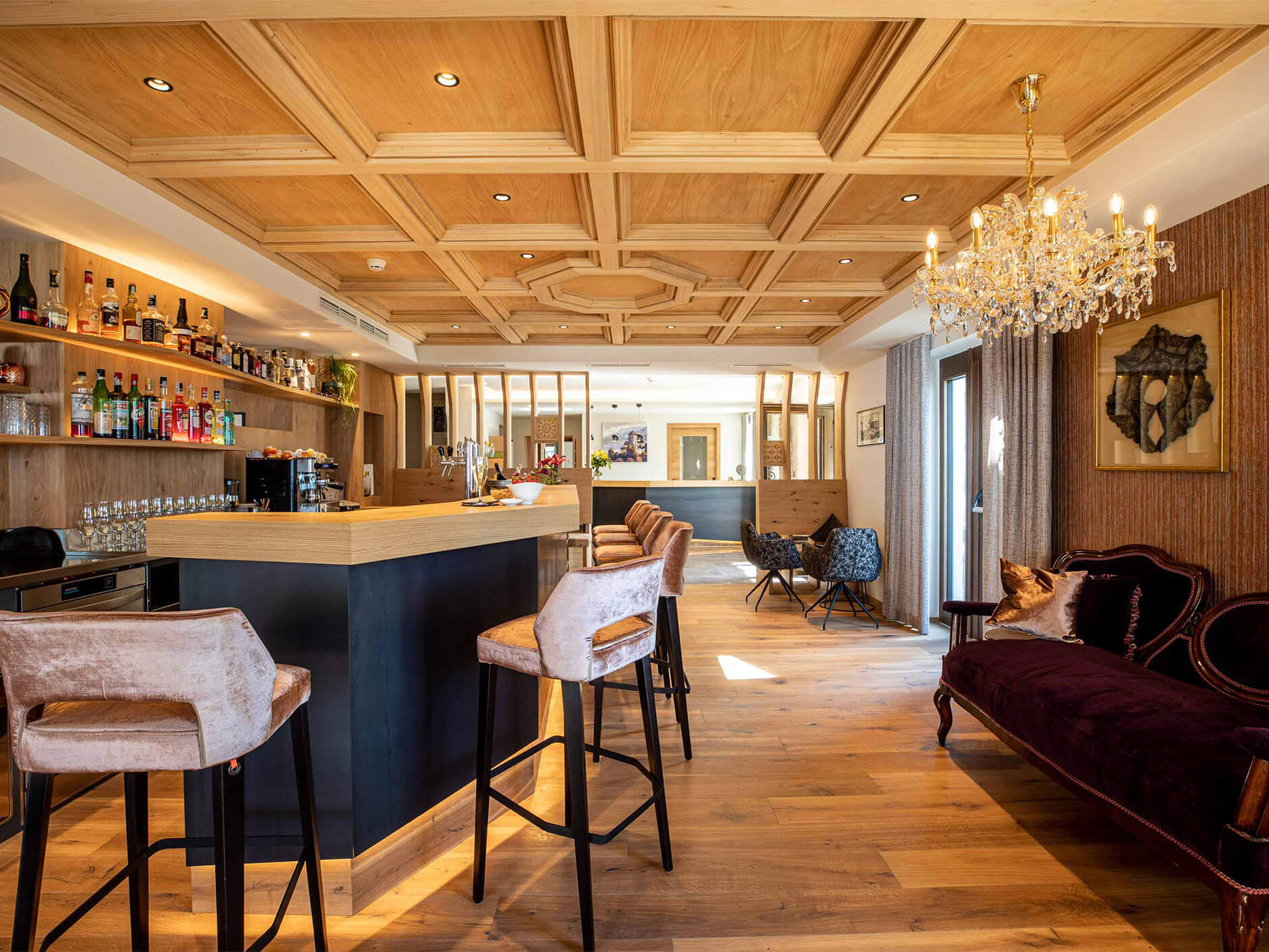 Barbereich mit Sesseln an der Theke und einem Kronleuchter - Hotel Patriarch