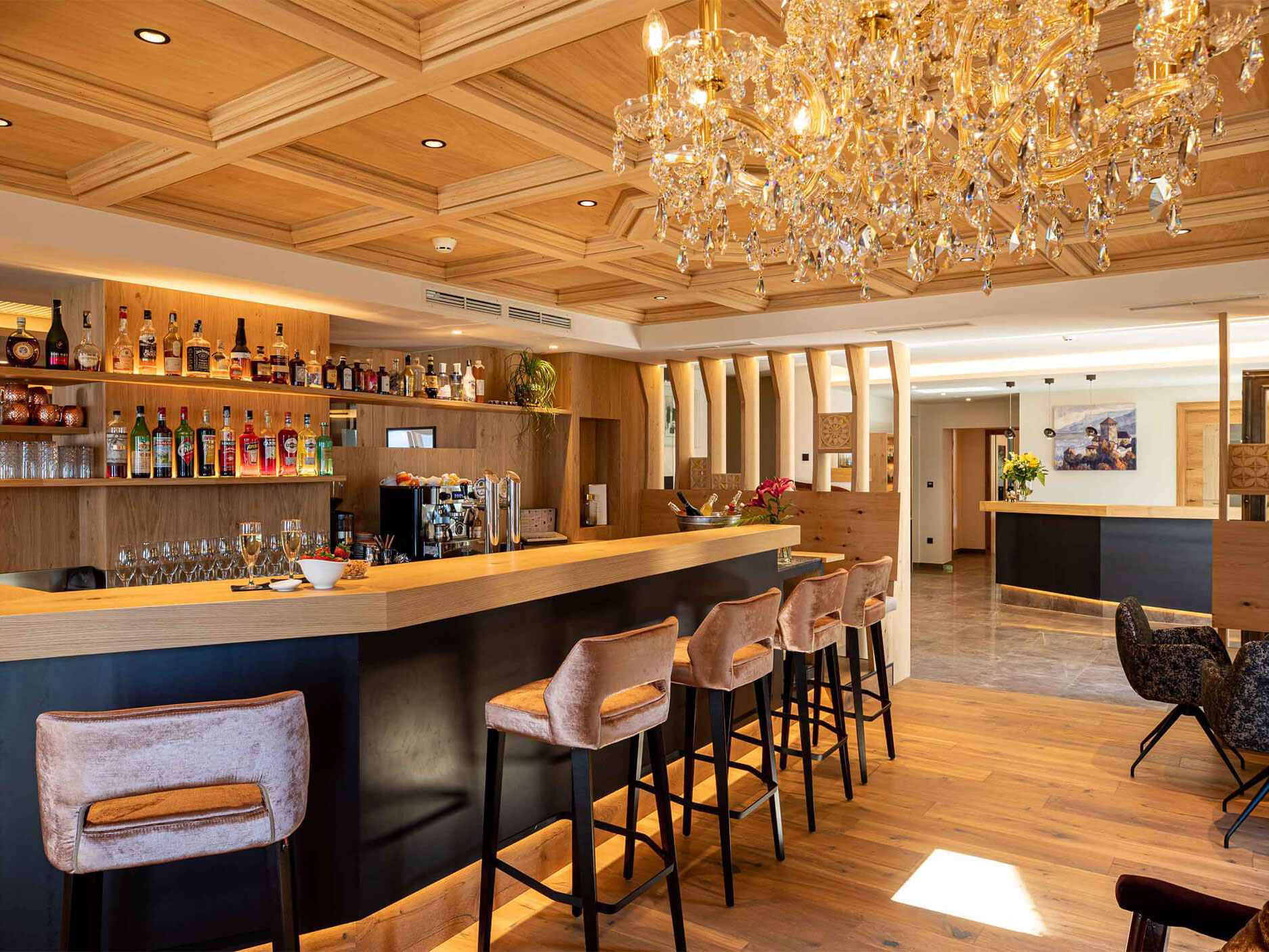 Die Bar aus Holz und schwarzen Elementen mit mehreren Hockern - Hotel Patriarch