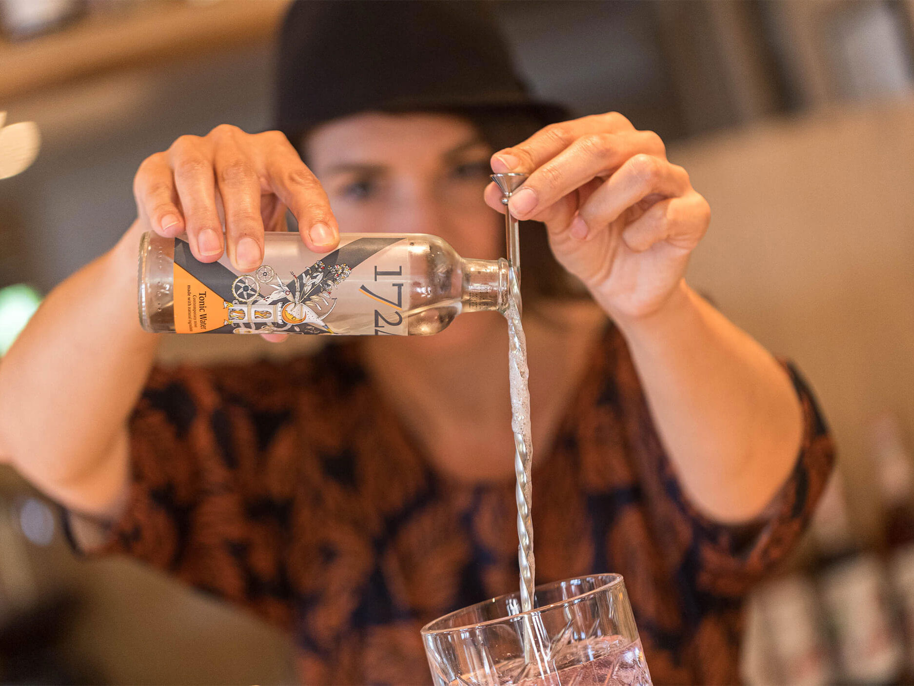 Tonic-Wasser wird über den Barlöffel ins Gin Tonic Glas geschüttet - Hotel Patriarch