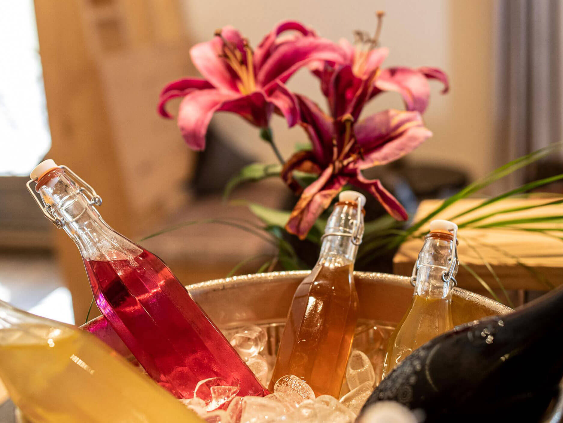 Verschiedene Flaschen mit Getränke und eine Sektflasche in einem Sektkühler mit Eis - Hotel Patriarch