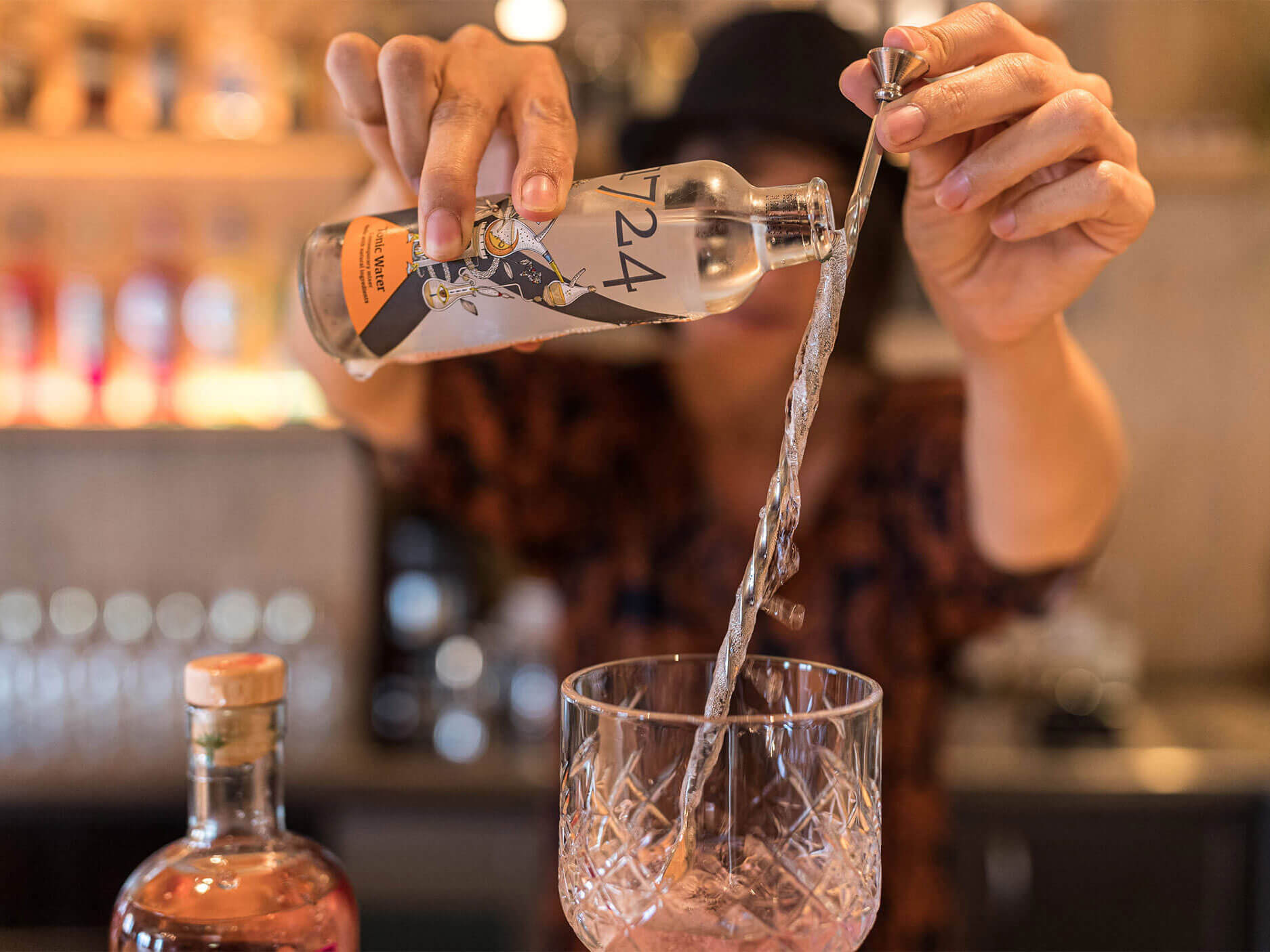 Tonic-Wasser wird über den Barlöffel ins Gin Tonic Glas geschüttet - Hotel Patriarch