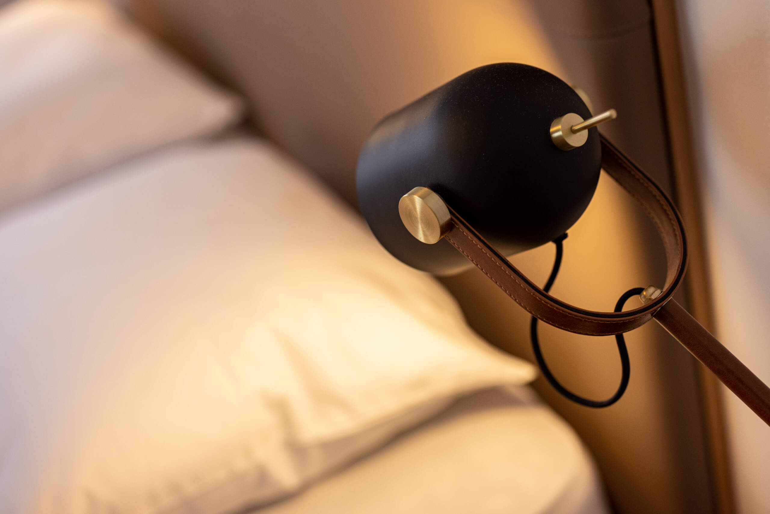 Eingeschaltete Nachttischlampe neben dem Bett - Hotel Patriarch