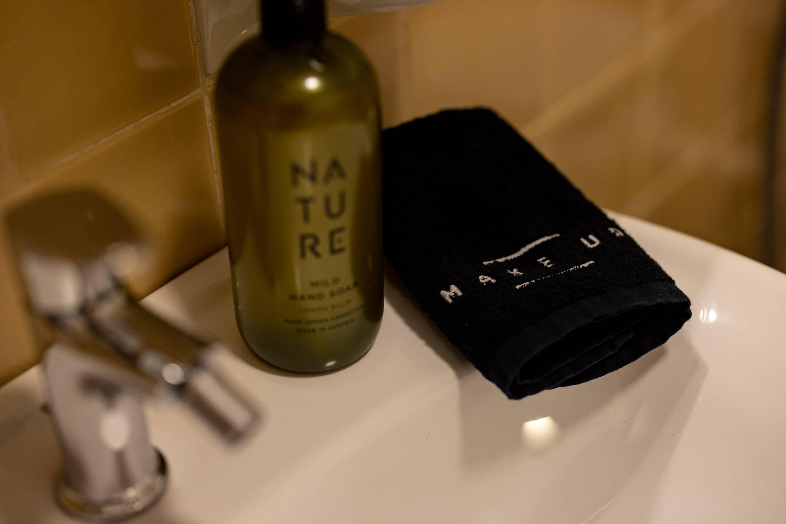 Flüssigseife und ein Handtuch am Waschbecken in der Ferienwohnung mit Hotelservice - Hotel Patriarch