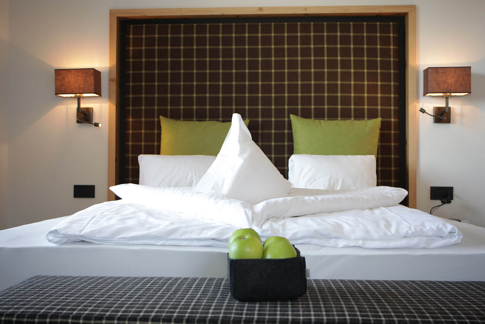 Doppelbett mit grünen Kissen und grünen Äpfeln in der Rosensuite zur Sonnenseite - Hotel Patriarch