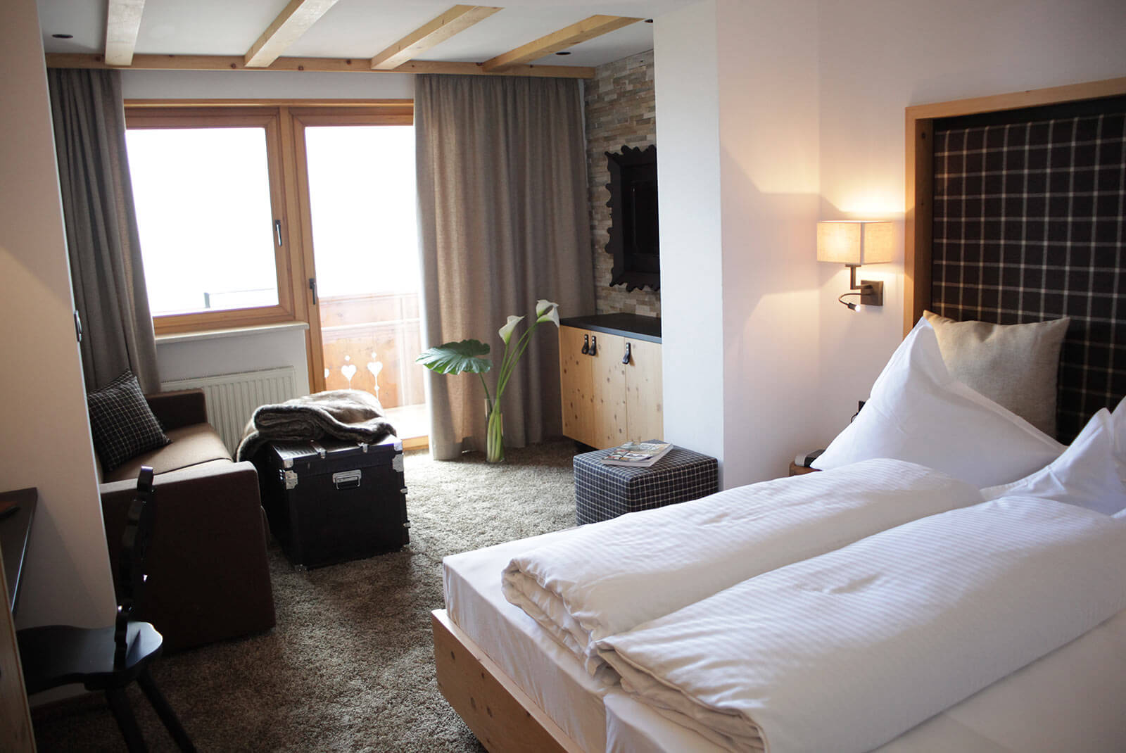 Doppelbett und kleiner Wohnbereich im Sonnenzimmer - Hotel Patriarch